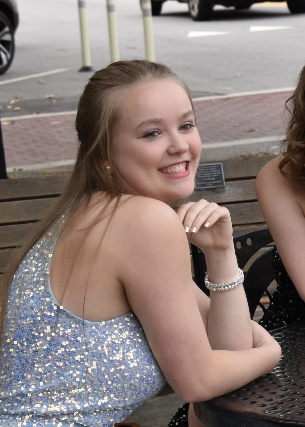 Candid portrait of Sarah at a table in a sparkly dress.